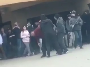 This screenshot of a cellphone video shows the moment a Clarke Road secondary school staff member was punched during a melee Thursday. He reacted with calm, ordering the attacker to leave the school grounds.