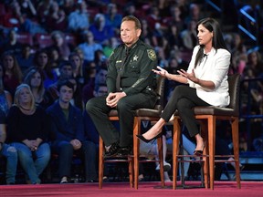 National Rifle Association spokesperson Dana Loesch answers a question while sitting next to Broward Sheriff Scott Israel during a CNN town hall meeting, Wednesday, February 21, 2018, at the BB&T Center, in Sunrise, Florida. South Florida Sun Sentinel Via AP.
