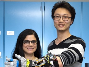 Engineering professor Ana Luisa Trejos and student Yue Zhou demonstrate a tremor suppression glove developed at Western University. The device offers people with Parkinson?s disease improved motor control. (Derek Ruttan/The London Free Press)