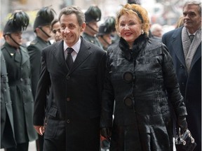 Jacqueline Desmarais, widow of Paul Desmarais, is accompanied by former French president Nicolas Sarkozy as they arrive at a memorial service for Paul Desmarais, Tuesday, December 3, 2013 in Montreal. THE CANADIAN PRESS/Paul Chiasson