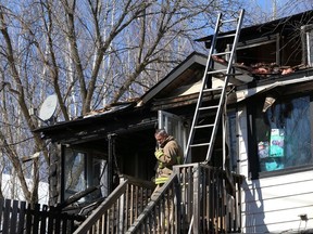 A firefighter stands outside a home on Edith Street in Sudbury where fire broke out on Saturday, March 3, 2018. Six people were evacuated without injuries, according to fire officials. John Lappa/The Sudbury Star/Postmedia Network