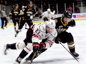 Owen Sound Attack's Aidan Dudas (27) protects the puck from Sarnia Sting's Kelton Hatcher (28) in the second period at Progressive Auto Sales Arena in Sarnia, Ont., on Sunday, March 4, 2018. (Mark Malone/Postmedia Network)