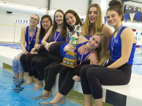 Alex Hicks, left, Lily Dong, Kathryn Shiplo, Suzie Blainey, Olivia Jantzie and Julie Villeneuve hold Kyra Moura, who holds the trophy the team won at the Canadian University synchronized swimming league championship recently at Brock University in St. Catharines. (Mike Hensen/The London Free Press)