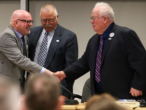 New councillor Garry Quinn shakes hands with Mayor Jim Harrison while Coun. David McCue looks on during a council meeting on Monday March 5, 2018 in Quinte West, Ont. Quinn was selected to fill a recently-vacated council seat. Tim Miller/Belleville Intelligencer/Postmedia Network