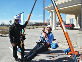 Jim Hogan, CEO of Entegrus, swings from a harness next to Jason McLoughlin, Canadian technical manager of Over the Edge in front of the Holiday Inn Express & Suites on Richmond Street in Chatham Monday. People who raise $1,000 or more in support of the Children's Treatment Centre Foundation of Chatham-Kent will be able to repel down the 10-story hotel June 23. (Tom Morrison/Chatham This Week)