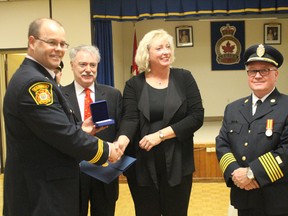 William Sheane, left, was among the recipients of the Governor-General's medal for exemplary service as a firefighter. Presenting the medals are from left Sarnia Mayor Mike Bradley, Sarnia-Lambton MP Marilyn Gladu and Sarnia Fire Chief John Kingyens. (NEIL BOWEN/Sarnia Observer)