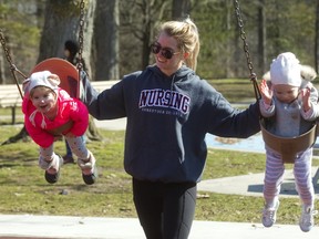 Eileigh Landon and Ellie Robinson get swung by Meaghan Rawlinson (Robinson's aunt) in the bright sunshine at the Springbank Park playground. (MIKE HENSEN, The London Free Press)