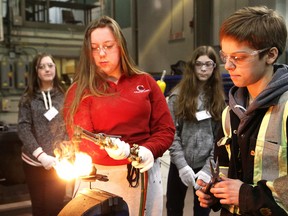 College Boreal welding student Jasmine Menard, right, looks on as Alyssa Belanger, 15, of Ecole secondaire catholique Champlain, tries her hand at shaping a metal flower in the welding shop at the Trades and Technology Exploration Day for young women at College Boreal in Sudbury, Ont. on Thursday March 8, 2018. More than 100 girls in high schools across Northern Ontario participated in interactive workshops and hands-on learning by operating tools and equipment used in various industries. John Lappa/Sudbury Star/Postmedia Network