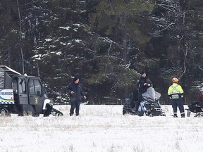 Members of Greater Sudbury Police and Emergency Medical Services gather in a field in Val Therese where the body of a missing woman was located. (Gino Donato/Sudbury Star)