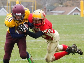 Regiopolios-Notre Dame Panthers Natha Pinder keeps a solid grip on the ball as he tries to run pas diving Sydenham Golden Eagles' Trevor Sutton during the first half of the Kingston Area Secondary School Athletic Association senior football quarter final game in Kingston in November. The photo earned Whig multimedia journalist Julia McKay an Ontario Newspaper Award nomination. (Julia McKay/The Whig-Standard)