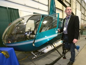 Pilot Dan Haupt shows a crop-dusting helicopter set up at the London Farm Show at the Western Fair Agriplex on Thursday. (MORRIS LAMONT/THE LONDON FREE PRESS)