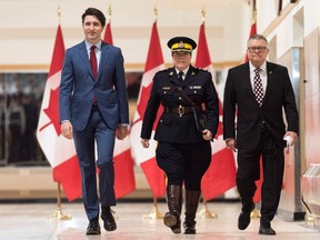 Brenda Lucki, center, Prime Minister Justin Trudeau, left, and Ralph Goodale, minister of public safety and emergency preparedness enter a press event at RCMP "Depot" Division in Regina, Saskatchewan on Friday March 9, 2018. THE CANADIAN PRESS/Michael Bell