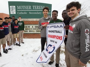 The Mother Teresa boys AA OFSAA basketball champions pose with their school sign and the banner they won Wednesday night in Pembroke. Left to right are Aidan Forsythe, Kyle Chea, Lorenzo Hakizimana, Shemar Rodriguez, Juan Ortiz, Emmanuel Akindele, Peyton Campbell, Aaron Tennant, Oren Rusagara, Joshua Lawrence and Mitchell Hartman. Photograph taken on Friday March 9, 2018.  Mike Hensen/The London Free Press/Postmedia Network