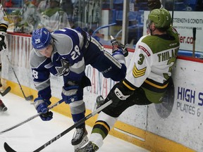 Drake Pilon, left, of the Sudbury Wolves, checks Adam Thilander, of the North Bay Battalion, into the boards during OHL action at the Sudbury Community Arena in Sudbury, Ont. on Friday March 9, 2018. John Lappa/Sudbury Star/Postmedia Network