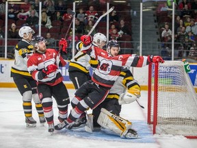 Ottawa 67's captain Travis Barron reaches for the crossbar as he falls into Kingston Frontenacs goalie Jeremy Helvig during an Ontario Hockey League game in Ottawa on Saturday, March 10, 2018. (Valerie Wutti/Blitzen Photography/OSEG)