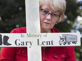 Kathleen Reed with a cross memorializing her partner Gary Lent, who was killed in a 401 collision. (Derek Ruttan/The London Free Press)