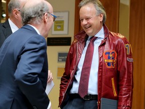 Stephen Poloz, governor of the Bank of Canada, right, wears his 1978 Queen's Arts & Sciences jacket as he speaks with Stephen J.R. Smith before addressing about 225 Queen's faculty, staff, students and members of the public at the Smith School of Business on Tuesday. (Ian MacAlpine/The Whig-Standard)