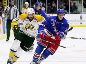 Sarnia Sting's Curtis Egert, left, and Kitchener Rangers' Alex Peterson chase the puck in the first period at Progressive Auto Sales Arena in Sarnia, Ont., on Saturday, Sept. 23, 2017. (Mark Malone/Postmedia Network)