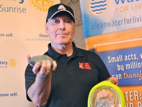 Gary Smith, owner of Red Devil Suba Supplies in Chatham, holds up a rock with iron ore he found on his diving adventures and a scuba mask following a presentation to the Rotary Club of Chatham Sunrise at Smitty's Restaurant on Tuesday. Tom Morrison/Chatham This Week