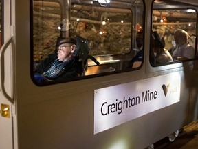 Professor Stephen Hawking traveling at the 6800-level of Creighton Mine to SNOLAB in a rail car specially designed by Anmar and Vale. Accompanying him is Dr. Art McDonald, who won the 2015 Nobel Prize for physics. (photo credit: Daniel Lalande)