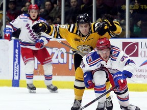 Kitchener Rangers' Austin McEneny (52) and Sarnia Sting's Jordan Ernst (16) battle for the puck in the first period at Progressive Auto Sales Arena in Sarnia, Ont., on Wednesday, March 14, 2018. (Mark Malone/Chatham Daily News/Postmedia Network)