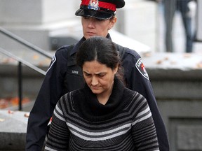 Tooba Mohammed Yahya walks into court with her Kingston police escort Krista Loye at the Frontenac County Court House in Kingston Ontario on Thursday Oct. 13 2011. She was found guilty in 2012 of murdering her three daughters in a so-called mass honour killing has been stripped or her permanent residency and ordered deported from Canada.  IAN MACALPINE KINGSTON WHIG-STANDARD