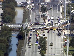 In this frame from video, emergency personnel work at the scene of a collapsed bridge in the Miami area, Thursday. (WPLG-TV via AP)