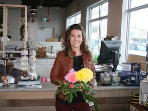 The Garden Gate Gifts & Florals owner Shannon Ryan stands with a bouquet of flowers in front of the cash at her Grand Bend store. She and The Garden Gate Gift & Florals will be handing out bouquets to their first 40 customers who come into the store on March 22. Customers will also receive an additional bouquet to give to someone special. (William Proulx/Exeter Lakeshore Times-Advance)