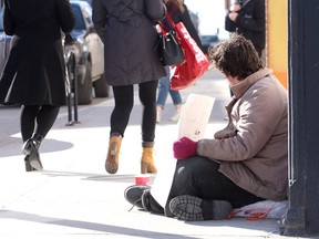 A 17-year-old homeless youth begs for change on Princess St. at the corner of Montreal Street in Kingston on Friday March 16 2018. Ian MacAlpine/The Whig-Standard/Postmedia Network