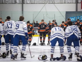 The Don Mills Flyers Bantam AAA team (back) took to the ice for the first time since their goalie Roy Pejcinovski was killed in a triple homicide to play a friendly scrimmage against the Toronto Marlboros in Toronto on Sunday, March 18, 2018. THE CANADIAN PRESS/Chris Donovan