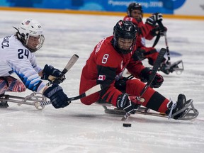 Joshua Misiewicz of the U.S. battles for the puck with Canada's Tyler McGregor of Forest, Ont., during the Ice Hockey Gold Medal Game between Canada and the United States at the Gangneung Hockey Centre in Gangneung, South Korea at the 2018 Winter Paralympics Sunday, March 18, 2018. (Bob Martin/via AP)