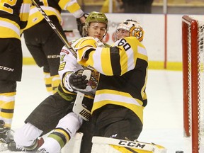 North Bay Battalion forward Brandon Coe collides with Kingston Frontenacs goaltender Jeremy Helvig after scoring to tie the game during the first period of Friday night’s Ontario Hockey League game at the Rogers K-Rock Centre. (Elliot Ferguson/The Whig-Standard/Postmedia Network)