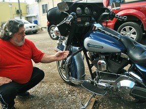 Jerome Lucier points out which parts of his motorcycle were repaired following what he calls a minor accident in the driveway of his Foster Street home in Chatham. Lucier said he received a new registration for the vehicle from his insurance company stating it had been branded irreparable after he had over $8,400 in repairs completed and received a lawsuit settlement from the insurance company. (Tom Morrison/Chatham This Week)