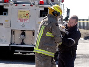 David Gough/Postmedia Network
A Chatham-Kent firefighter hands off a cat to an animal control worker following an apartment fire at 800 Wallace Street on Sunday March 18, 2018. The entire apartment building was evacuated due to the fire.