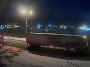 A semi truck goes through an activated rail crossing on Dahl Drive in January just as a train going in reverse is about to cross (Submitted | CN).