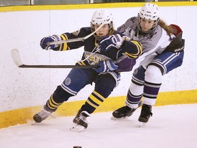 Kelsey Dunn of the College Notre Dame Alouettes  battles for the puck with Katie Chomiak of the Lo-Ellen Park Knights during the N.O.S.S.A. girls hockey championship game in Sudbury, Ont. on Tuesday March 6, 2018. Gino Donato/Sudbury Star/Postmedia Network