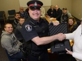 Submitted photo
Const. Brad Stitt accepts a new Lidar speed detection device from Belleville Community Policing at a recent presentation. Pictured with Stitt is community policing chairwoman Ann Carr, who explained the organization donated the funds to purchase the new speed measuring device. Lidar uses a narrow laser beam to easily target specific vehicles over a large distance as compared to traditional radar devices. While the Traffic Safety Unit has been using a Lidar for several years, Stitt advised this particular device would be deployed for use by officers on general patrol and “is a very welcome tool to help keep our community and roadways safe.” Pictured behind Stitt and Carr are members of the Belleville Community Policing Committee.