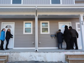 The Moedt family and the Lovelace family unlocked the doors to their new homes in Kingston. (Meghan Balogh/The Whig-Standard)