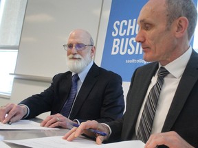 Stephen Havlovic, dean of the faculty of management at Laurentian University, and Colin Kirkwood, vice-president academic at Sault College, sign a business studies agreement on Wednesday.