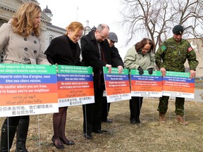Kingston Mayor Bryan Paterson, third from left, places an immigration-welcoming lawn sign in the soft ground of Confederation Park across from City Hall on Wednesday. Joining him, from left, are Chantal Blachette from the Francophone Immigration Support Network, Donna Gillespie of KEDCO, Coun. Jim Neill, Michelle Dubois of ACFOMI, and Canadian Forces Base Kingston base commander Col. Patrick Lemyre. (Ian MacAlpine/The Whig-Standard)