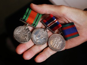 Luke Hendry/The Intelligencer 
Doug Moreau holds the medals of his late father, Cpl. Lorne Moreau. Lorne Moreau died in a Second World War plane crash in Germany. Volunteers now plan to excavate the site and their research has given Doug Moreau new details about his father's life and death.