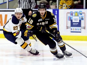 Sarnia Sting's Anthony Salinitri (10) protects the puck from Erie Otters' Ivan Lodnia (27) in the second period at Progressive Auto Sales Arena in Sarnia, Ont., on Saturday, Feb. 24, 2018. (Mark Malone/Postmedia Network)