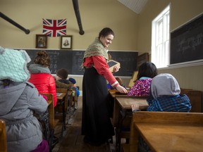 Teacher Lily Foris, who works at the Fanshawe Pioneer Village, hands out slates to students so they could learn "penmanship," a new word to most of them. Families came to the village to take advantage of the 3rd annual free drop-in day and learned a little about what school was like in a one room schoolhouse. Fanshawe Pioneer Village is also featuring a new exhibit that explores women’s work during the Victorian era. (Mike Hensen/Postmedia News)