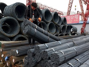 A worker loads steel products onto a vehicle at a steel market in Fuyang in central China's Anhui province Friday, March 2, 2018. The government is taking further steps to crack down on companies that try to ship cheap foreign steel and aluminum through the Canadian market. THE CANADIAN PRESS/Chinatopix Via AP