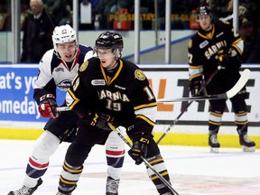 Sarnia Sting's Ryan McGregor (19) is chased by Windsor Spitfires' Curtis Douglas (39) in the second period during Game 1 in their OHL Western Conference quarter-final at Progressive Auto Sales Arena in Sarnia, Ont., on Friday, March 23, 2018. (Mark Malone/Chatham Daily News/Postmedia Network)