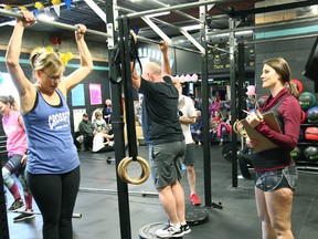 Diane Anderson takes a couple seconds to regroup from pull-ups while Emily Hendricks cheers her on. (Shaun Gregory/Huron Expositor)