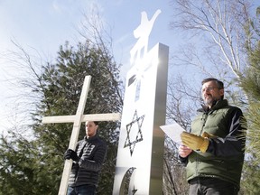 Cedric Dumais, holding the cross, stands next to the second station as father David Shulist reads the scripture,  during the University of Sudbury's reenactment of the Way of the Cross in Sudbury, Ont. on Friday March 30, 2018. Gino Donato/Sudbury Star/Postmedia Network