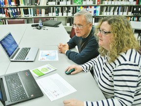 Merv Howes and Angela Churchill take a look at some DNA results through an online program inside the Kent branch of the Ontario Genealogical Society room at the Chatham branch of the Chatham-Kent Public Library on March 28. Tom Morrison/Chatham This Week