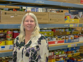 Executive Director Lori McRitchie poses with some of the stockpiled canned goods at the Airdrie Food Bank on Thursday, March 29. In 2018, the food bank has hit record-breaking numbers of families coming in for assistance.