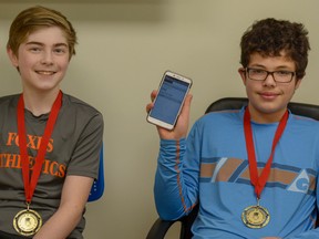 Grade 8 students Caleb Dreher and Paul Milan Diaz show off the tourism app they developed at the JunioTech Hackathon at the University of Calgary. Along with their team, they won first place at the competition.